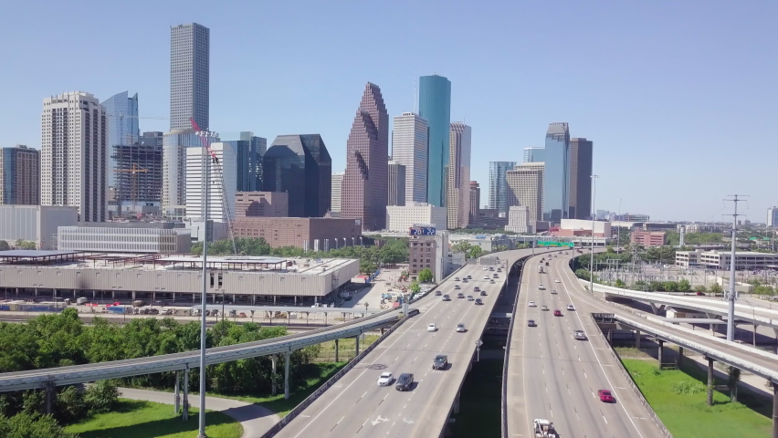 Establishing drone shot of Downtown Houston from I10 and I45 intersection. Revealing aerial shot downtown Houston with high skyscrapers. Intro video of Houston. Downtown transportation in sunny day