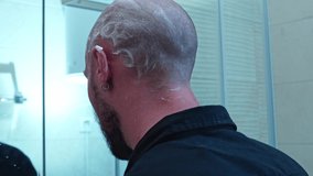 man with shaving foam on his head shaving his hair with a machine with shaving blades. A man shaves his bald head with a razor. man in the bathroom shaving his head with a razor with blades. - Powered by Shutterstock - Get 15% off with code: PIKWIZARD15