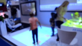Blurred background. Two children playing in the game, which the projector projects on the floor.