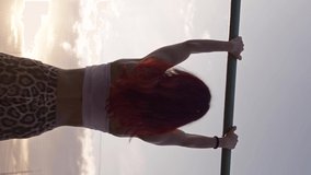 Vertical Video, Athletic Woman Pulls up on Horizontal Bar on Background of a Beautiful Sunset. Female Athlete Trains Outdoors. Workout and Healthy Lifestyle. Slow Motion.