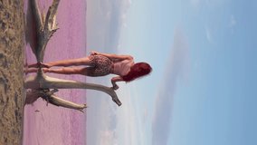 Vertical Video, Happy Woman Traveler Raises Her Hand Up While Standing on Background of a Beautiful Pink Lake and Sky Horizon. Travel and Freedom Concept. Active Lifestyle and Summer Time. Slow Motion