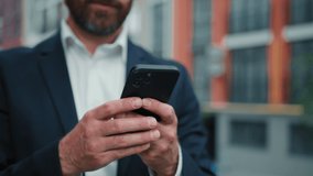 Inspired successful adult caucasian businessman bearded wealthy man stand in city hold smartphone use mobile phone outdoor work online search information texting messages distant chat cell connection - Powered by Shutterstock - Get 15% off with code: PIKWIZARD15
