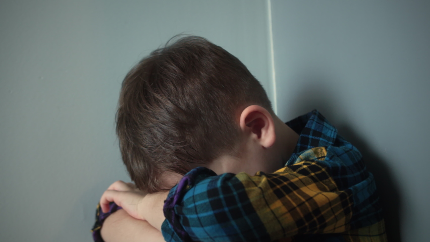Portrait of a Cute boy with big tears running down his cheeks, Sad upset boy sitting in corner lifestyle.Child punished sitting crying in the corner. Domestic violence concept. Child abuse | Shutterstock HD Video #1095422215