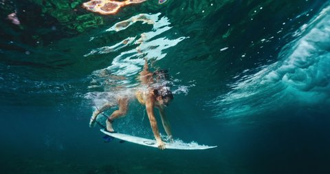 Surfer girl duck dives under large ocean wave, underwater cinematic slow motion Video de stock