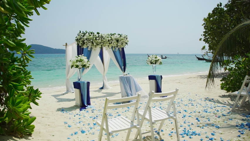 Wedding arch white sand beach. Tropical Palm tree island summer paradise. Sea blue sky clouds. Sand sea water turquoise. wedding decoration outdoor. Organization chairs table setting marriage.   Royalty-Free Stock Footage #1095428597