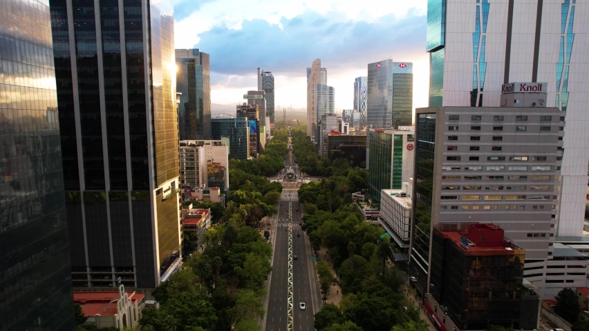 drone shot in reverse of a sunset on the paseo de la reforma in mexico city with a view of the monument to independence Royalty-Free Stock Footage #1095431351