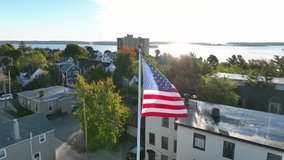 Portland Maine. Aerial establishing shot of Munjoy Hill neighborhood. Casco Bay and Atlantic Ocean sunlight reflection. American flag. - Powered by Shutterstock - Get 15% off with code: PIKWIZARD15