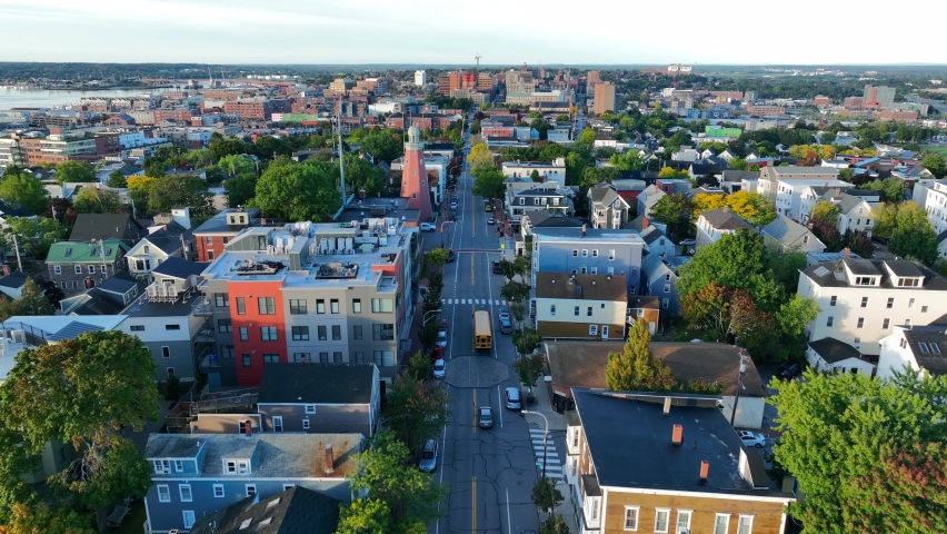 Aerial of Portland Maine and Observatory. Aerial shot tracks school bus on road. Beautiful golden hour light. Royalty-Free Stock Footage #1095431631