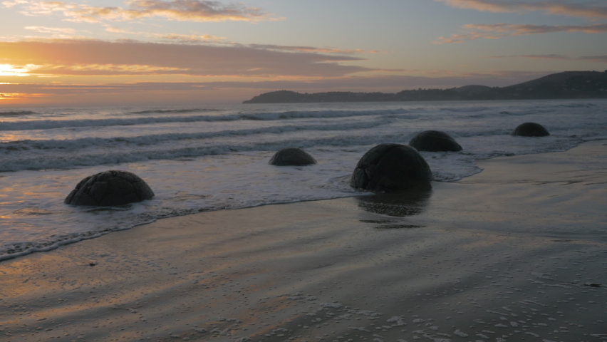 Sunrise on the Moeraki Boulders on the beach, in New Zealand