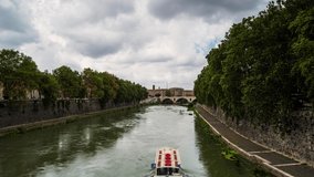 Time lapse video with Ponte Principe Amedeo Savoia Aosta over Tiber River in Rome, Italy, with fast moving rain clouds and the rushing waters of the river.
