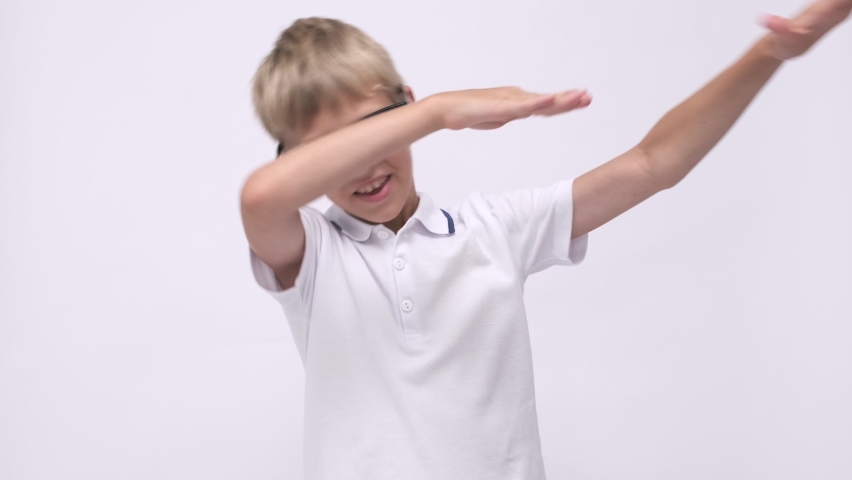 Portrait Schoolboy with glasses on a white background. Back to school. Funny boy thumbs up and smiles. The student laughs and rejoices. Happy positive child. Happy schooling.