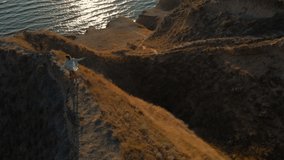 aerial happy woman running on hill top edge with panoramic view at sunset with welsh corgi dog. beautiful girl enjoying adventure in nature. Stanislav canyon, Ukraine. clip has noise