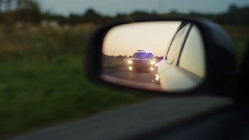 Side Mirror of Criminal Car Chase Shot: Highway Traffic Patrol Car In Pursuit of Suspect Vehicle. Police Officers in Squad Car Chase Felon on Road. Stylish Cinematic Atmospheric High Speed Action | Shutterstock HD Video #1095441771
