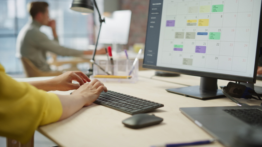 Close Up Footage of Woman's Hands Working on Keyboard and Monitor. Young Woman's hands Moving the Computer Mouse and Typing. Female Sales Manager Developing a Time Management Plan. Dolly Shot.
