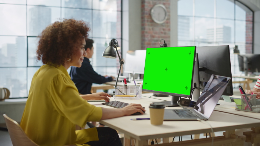 Portrait of Biracial Creative Young Woman Working on a Green Screen Computer in Bright Busy Office. Female Team Lead Smiling Happily While Checking Performance Data. Zoom In Shot | Shutterstock HD Video #1095443331