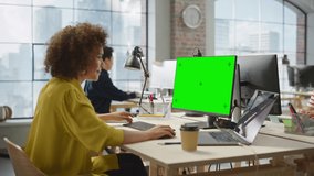 Portrait of Biracial Creative Young Woman Working on a Green Screen Computer in Bright Busy Office. Female Team Lead Smiling Happily While Checking Performance Data. Zoom In Shot - Powered by Shutterstock - Get 15% off with code: PIKWIZARD15
