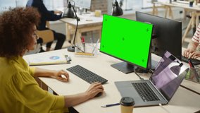 Portrait of Biracial Creative Young Woman Working on a Green Screen in Bright Busy Office During Day. Female Recruiter Smiles While Checking Job Candidates. People Working in the Background. - Powered by Shutterstock - Get 15% off with code: PIKWIZARD15