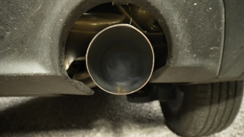 4K:  Exhaust Pipe on a Car emitting smoke fumes and pollution. Probe Lens Inside. Stock video clip footage