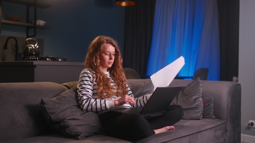 Woman rejoice, celebrate start-up competition victory, promotion at work, hired job of dream. Girl checks news, mail about success on laptop, happily throws papers away sitting in living room at home. | Shutterstock HD Video #1095448005