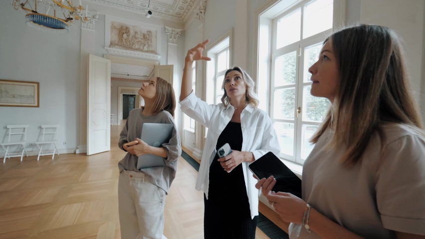 Creative team of event organization consulting discussing to woman customer interior decor wedding preparation young professional female decorators contemplation mansion hall for element arrangement