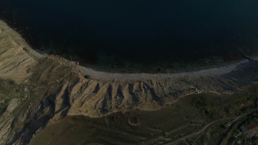 Top view of coast line with blue water. Shot. Wild coast with deep blue color of sea water. Coast of abandoned quarry with blue water