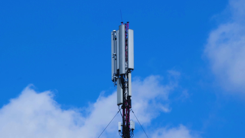 Cell site antenna on a blue sky and white clouds background. Cell tower with mobile Telecommunications equipment. Place for text. Cellular tower base station with electronic communications equipment Royalty-Free Stock Footage #1095457673