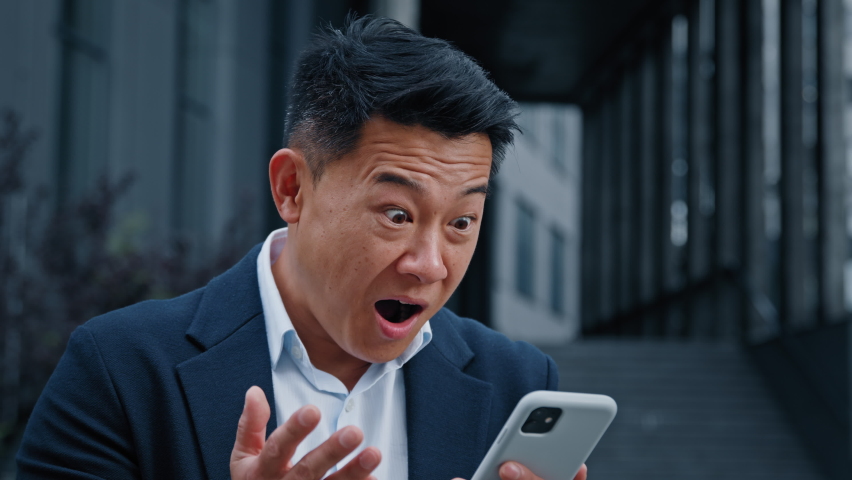 Happy excited 50s years winner businessman leader man has business chat in smartphone receive good news winning with mobile cell phone great big win prize amazed shocked face standing outdoors in city Royalty-Free Stock Footage #1095458797