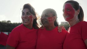 Senior sport fans celebrating with crowd cheering red football team on stadium tribune - Soccer spectators watching match game during event. - Powered by Shutterstock - Get 15% off with code: PIKWIZARD15