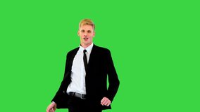 Witty guy in black office suit performs funny dance and sits on a twine in the end on a Green Screen, Chroma Key. - Powered by Shutterstock - Get 15% off with code: PIKWIZARD15