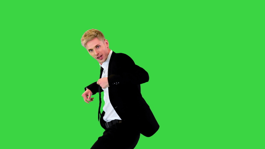 Very confident b-boy in office suit makes aerial jump on a Green Screen, Chroma Key.