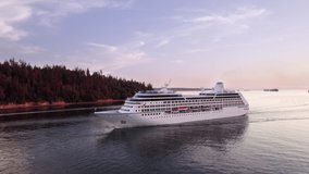 Cruise ship sailing out of Vancouver harbour at sunset, cruise line, large boat, luxury cruise, aerial footage. 4K 4096x2304 PRORES 24FPS.