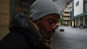 A close-up clip of a black man in warm clothes looking looking in to the camera in Leicester's City Centre.