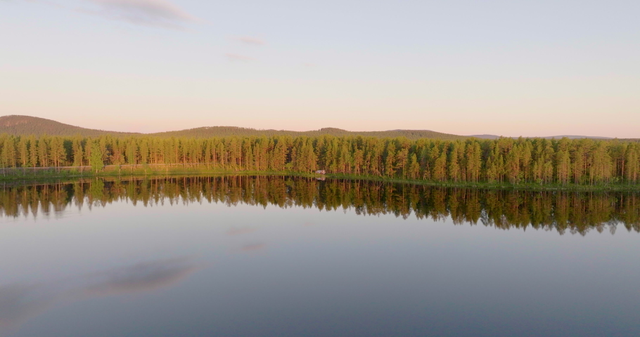 Spruce Forest With Mirror Reflection On Transparent Lake In Lapland, Northern Sweden. Aerial Drone Shot