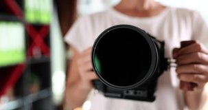 Shiny glass of the camera lens in the hands of a woman
