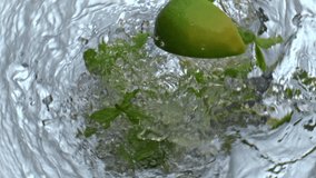 Lime mint falling water glass top view. Fresh citrus slices throwing in sparkling detox drink macro. Mojito bubbled cocktail transparent container closeup. Summer refreshing beverages concept  - Powered by Shutterstock - Get 15% off with code: PIKWIZARD15