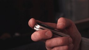 Man holds an outdated clamshell mobile phone in his hand, opens it, dials a number and closes it back, close up - Powered by Shutterstock - Get 15% off with code: PIKWIZARD15