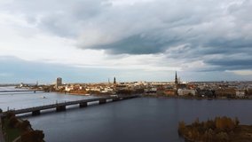 Aerial View of Riga City the Capital of Latvia. Amazing View on the River Daugava, Old Town, National Library, Bridges Over the River and the Main Tv Tower. View From Above During Autumn Cloudy Day 4K