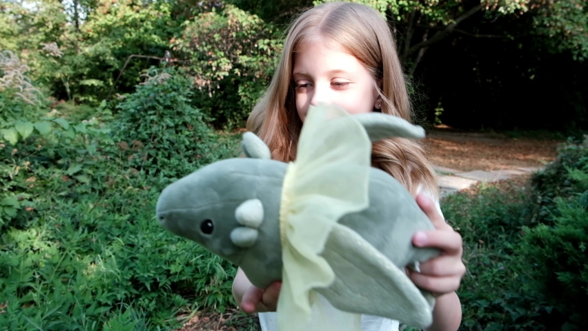 Little girl playing with a soft toy in the park