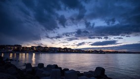 View of magical brilliant bewitching reflection in calm blue quiet Black Sea, against background of sea horizon with cloudy multi-colored sky and bright evening sunset. 4K UHD timelapse video