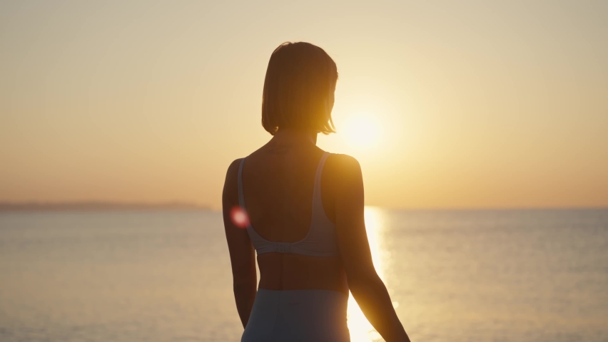 Silhouette Woman practice yoga pose to meditation with summer vacation beach happiness and relaxation. Calm female exercise with yoga meditate ocean beach with sunset golden time. Mental health Royalty-Free Stock Footage #1095532785