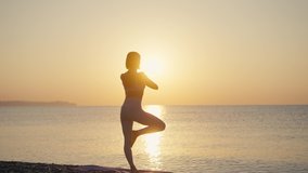 Silhouette Woman practice yoga pose to meditation with summer vacation beach happiness and relaxation. Calm female exercise with yoga meditate ocean beach with sunset golden time. Mental health - Powered by Shutterstock - Get 15% off with code: PIKWIZARD15