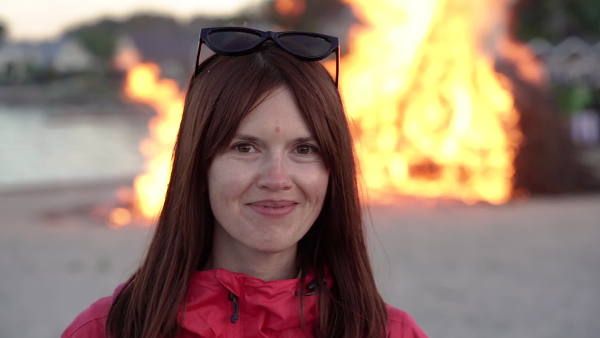 Bonfire. Portrait of a woman in front of a large fire.