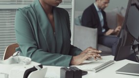 Tilt up slowmo of focused young African American female software engineer typing on computer sitting at office desk with virtual reality headset on it - Powered by Shutterstock - Get 15% off with code: PIKWIZARD15