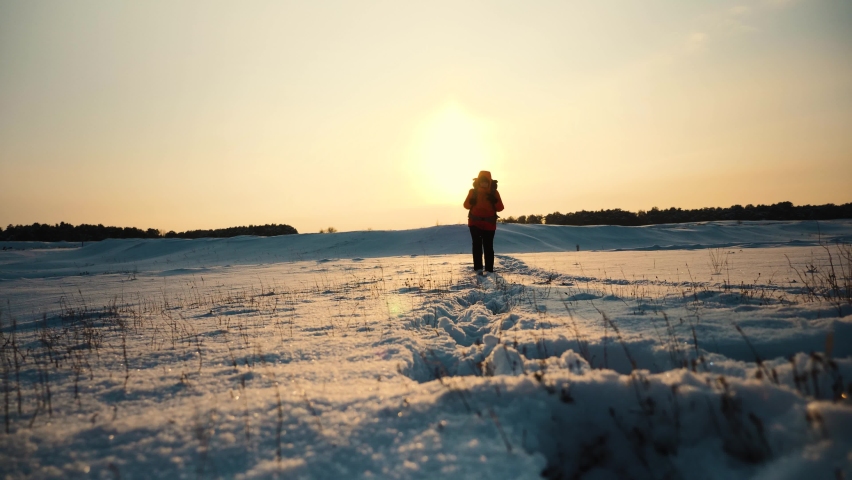 traveler snowy mountains with backpack sunset walks through snow. climber travels alone winter. walk through winter forest. hiking snow. active young man walks with his feet snow sunrise. concept
