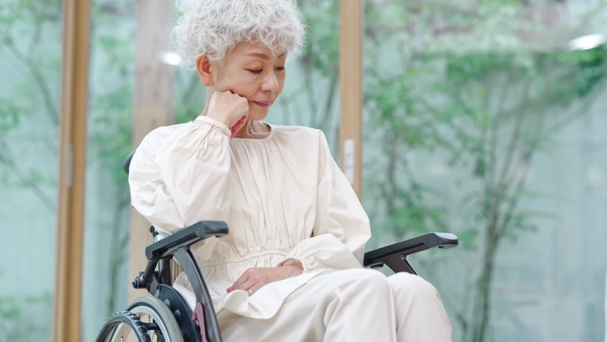 Depressed elderly Asian woman sitting on wheelchair. Royalty-Free Stock Footage #1095534257