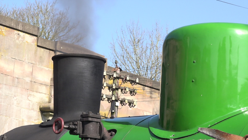 Close up of steam train and smoke coming out while it is in station England UK 4K