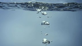 Big shiny air bubbles rising up on calm surface of water and bursting. Freshness of clear blue liquid poured into container. Transparent blue aqua with light glare. Close up liquid through the glass. - Powered by Shutterstock - Get 15% off with code: PIKWIZARD15