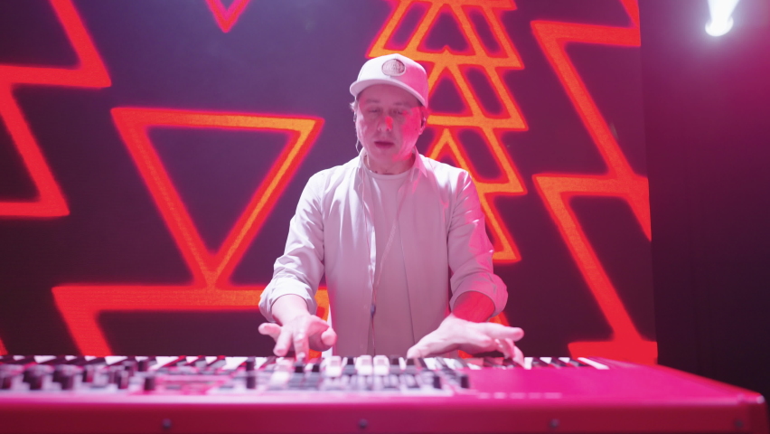 keyboard player is playing energetically on stage during rock or hip-hop music gig, portrait of man - Powered by Shutterstock - Get 15% off with code: PIKWIZARD15