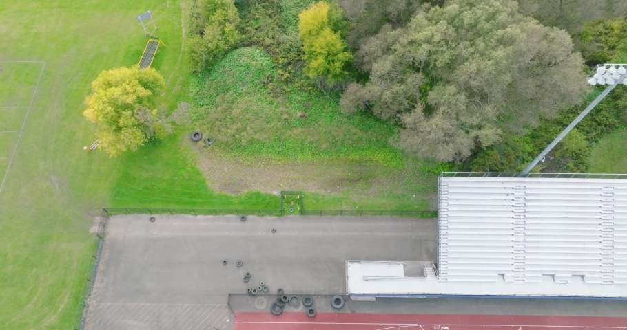 Aerial video of aluminum stadium bleacher, dolly move, sliding past an empty set of grandstands.  