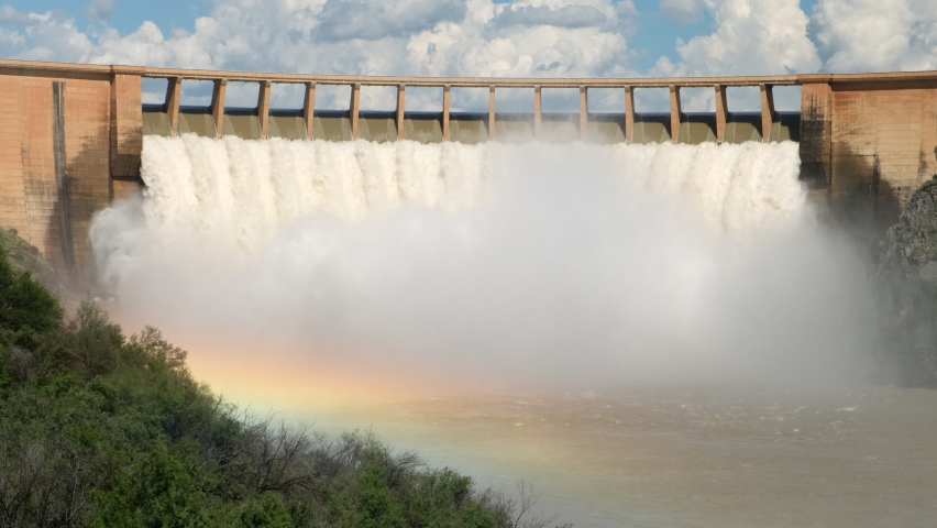 hydroelectric power station. a large hydroelectric power plant and a huge stream of water falls into the river. Vertical hydro electric generators inside dam. rainbow Royalty-Free Stock Footage #1095560601